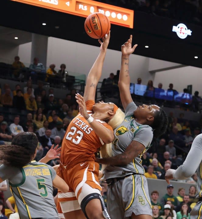 Texas forward Aaliyah Moore (23) shoots between Baylor guard Darianna Littlepage-Buggs (5) and forward Dre’Una Edwards, right, in the first half of an NCAA college basketball game, Thursday, Feb. 1, 2024, in Waco, Texas. (Rod Aydelotte/Waco Tribune-Herald via AP)