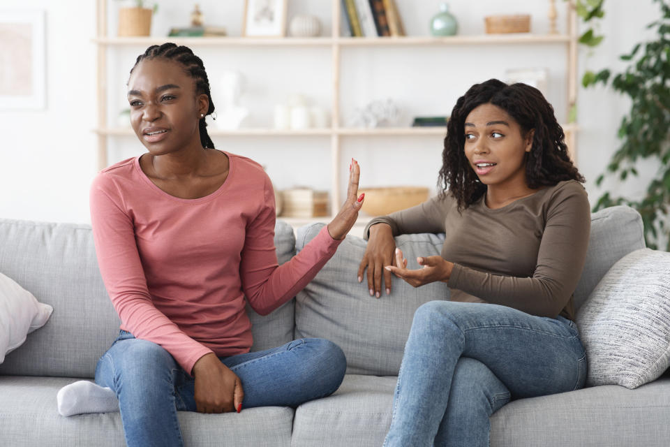 one person giving the hand to someone while sitting next to them on the couch