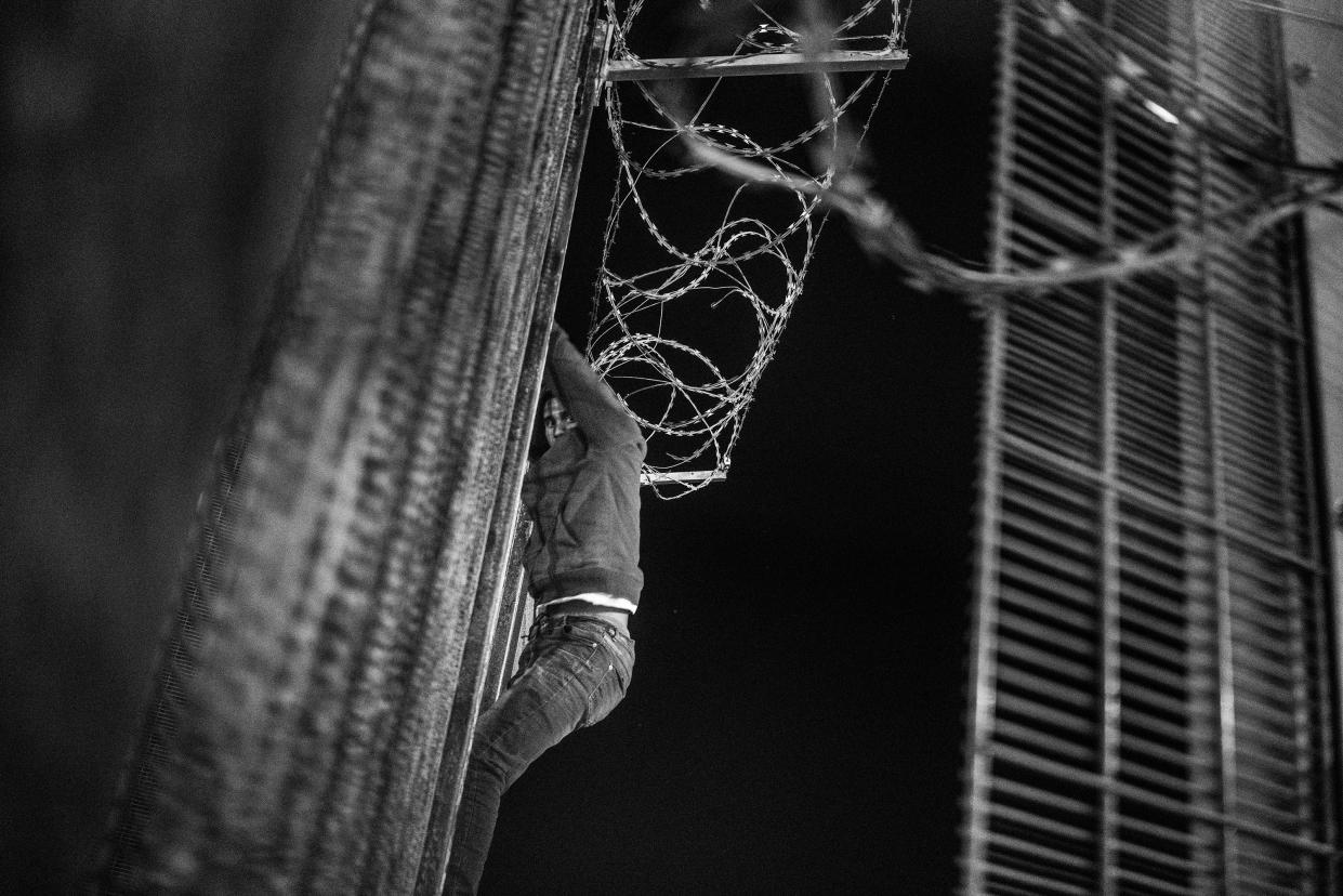 A young migrant of Moroccan origin jumps the fence that surrounds the port of Melilla in June. (Photo: José Colón/MeMo/Sony for Yahoo News)