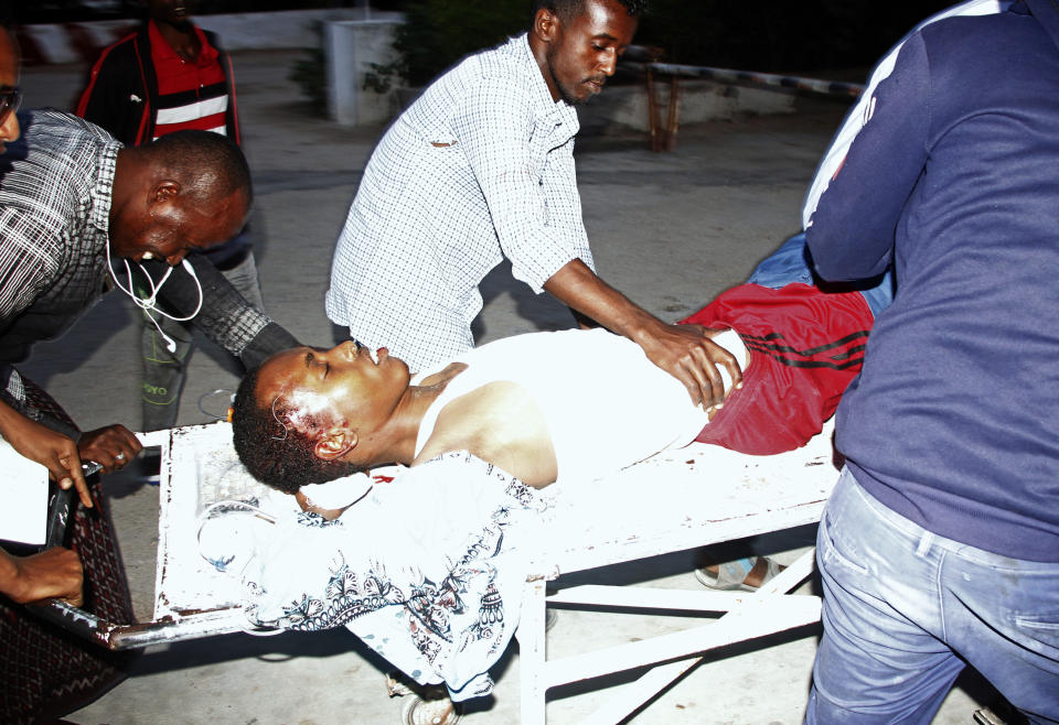 Medical workers help civilian on stretcher who was wounded in suicide bomb, at Madina hospital, Mogadishu, Wednesday, July 24, 2019. A suicide bomber walked into the office of Mogadishu's mayor and detonated explosives strapped to his waist, killing several people and badly wounding the mayor, Somali police said Wednesday. (AP Photo/Farah Abdi Warsameh)