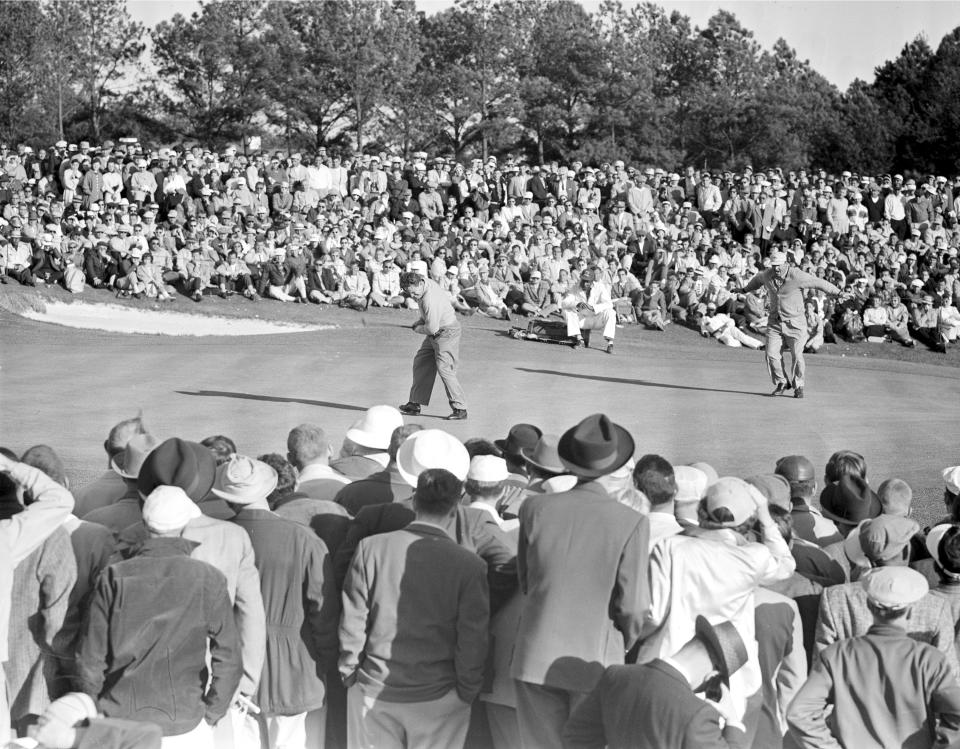 FILE - Jack Burke Jr. reacts as his winning putt drops on the 18th hole in the Masters Golf Tournament at the Augusta National Golf Course in Augusta, Ga., April 8, 1956. At right, partner Mike Souchak spreads his arms and lets out a whoop. Jack Burke Jr., the oldest living Masters champion who staged the greatest comeback ever at Augusta National for one of his two majors, died Friday morning, Jan. 19, 2024, in Houston. He was 100. (AP Photo/File)