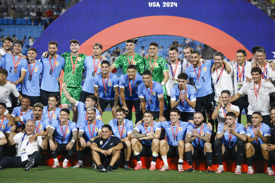 Los jugadores de la selección de Uruguay posan con sus medallas de tercer lugar tras vencer a Canadá en la Copa América, el sábado 13 de julio de 2024, en Charlotte, Carolina del Norte (AP Foto/Nell Redmond)