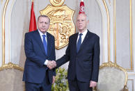 Turkey's President Recep Tayyip Erdogan, left, and Tunisian President Kais Saied shake hands before a meeting, in Tunis, Tunisia, Wednesday, Dec. 25, 2019. Erdogan with top Turkish officials is on an unannounced visit to Tunisia to meet Saied. (Slim Abid/Tunisian Presidency via AP)