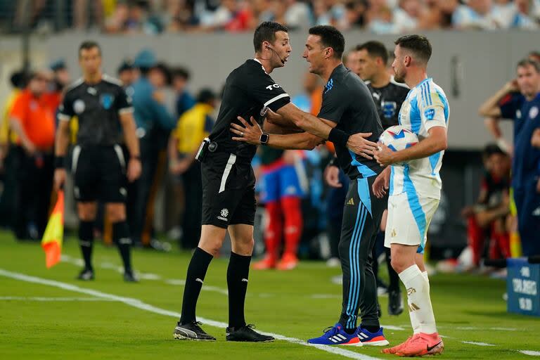 Lionel Scaloni habla con el árbitro uruguayo Andrés Matonte; el director técnico ensayó varios reclamos al cuarto árbitro Gustavo Tejera durante el partido