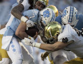 North Carolina quarterback Sam Howell (7) is sacked by Notre Dame's Marist Liufau (35) and Drew White (40) in the second quarter of an NCAA college football game, Friday, Nov. 27, 2020, at Kenan Stadium in Chapel Hill, N.C. (Robert Willett/The News & Observer via AP)