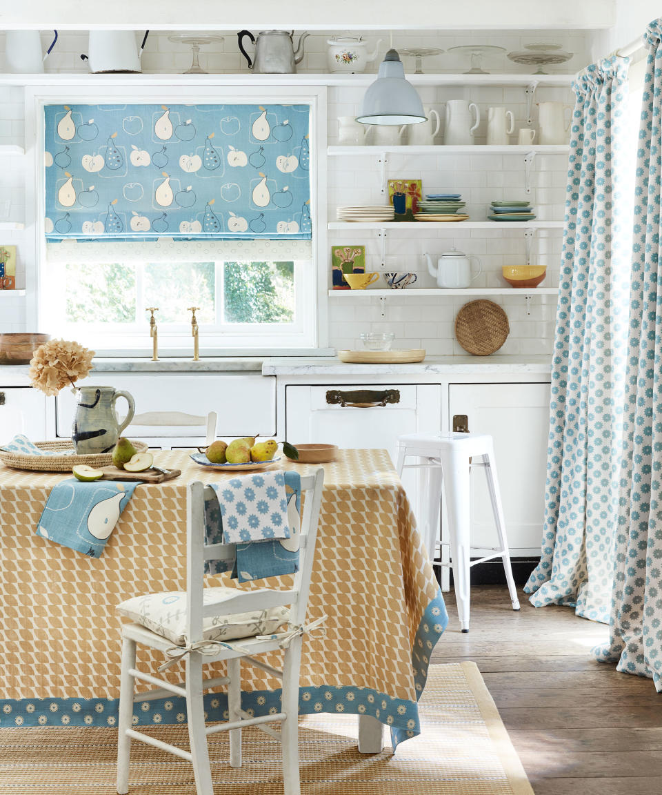 15. Add a pop of color to a traditional white kitchen with a pretty blind