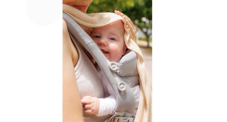 Baby in carrier under The Cowrie.