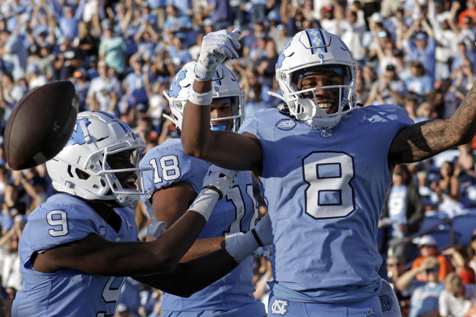 North Carolina wide receiver Kobe Paysour (8) celebrates his long touchdown reception and run against Syracuse with teammates wide receiver Devontez Walker (9) and tight end Bryson Nesbit (18) during the second half of an NCAA college football game, Saturday, Oct. 7, 2023, in Chapel Hill, N.C. (AP Photo/Chris Seward)