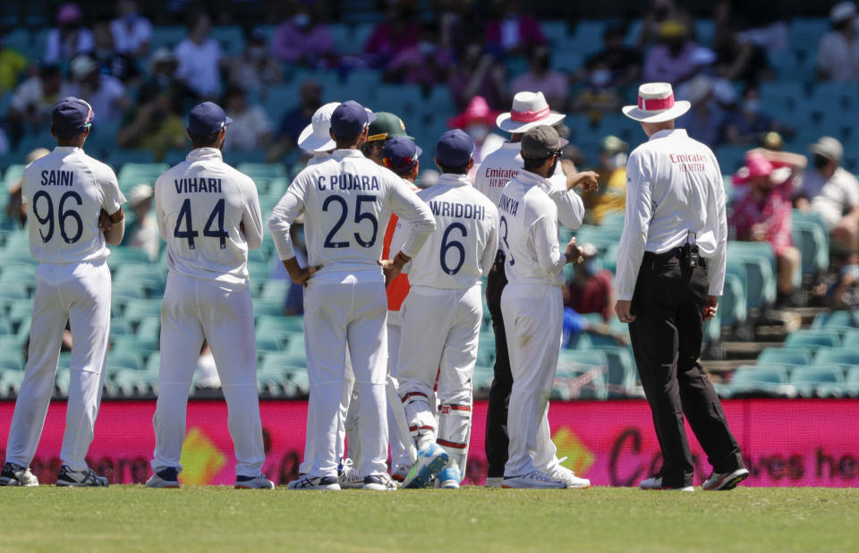 Indian players talk with the umpires after an issue with the crowd during play on day four of the third cricket test between India and Australia at the Sydney Cricket Ground, Sydney, Australia, Sunday, Jan. 10, 2021. (AP Photo/Rick Rycroft)