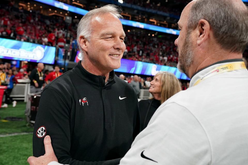 Former Georgia Bulldogs head coach Mark Richt, left, greets Chick-fil-A Peach Bowl CEO Gary Stokan during the 2022 College Football Playoff semifinal in Atlanta on Dec. 31.