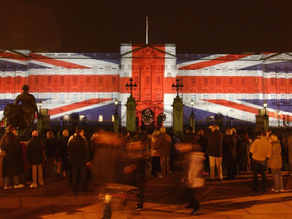 Buckingham Palace decorated for Christmas with a projection of the British flag.