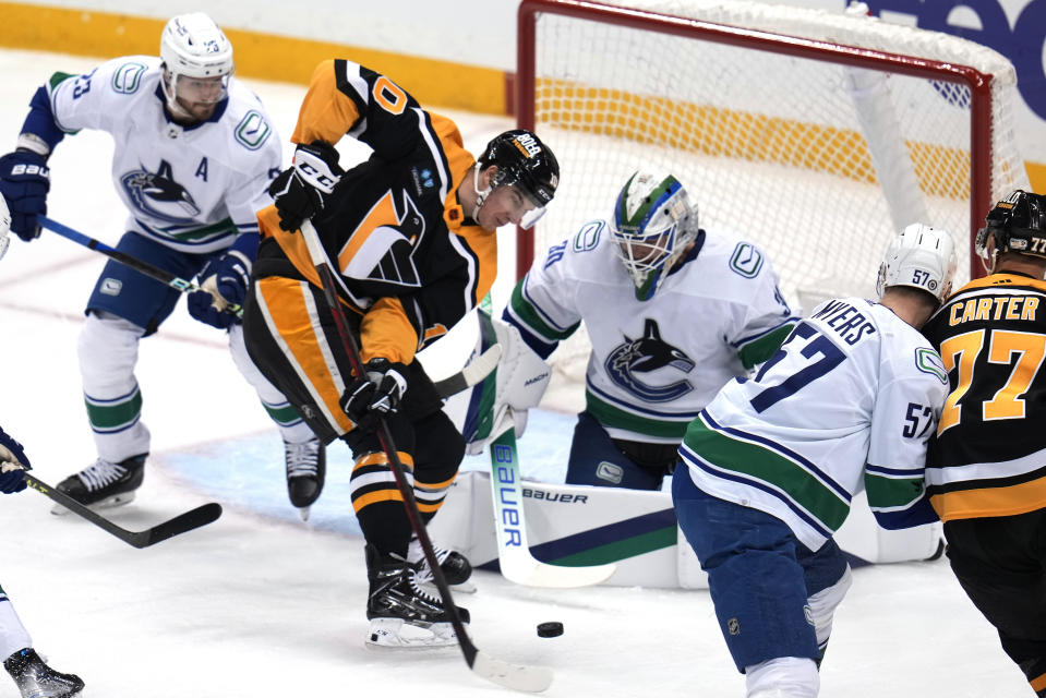 Pittsburgh Penguins' Drew O'Connor (10) tries to get a shot off in front of Vancouver Canucks goaltender Spencer Martin (30) during the first period of an NHL hockey game in Pittsburgh, Tuesday, Jan. 10, 2023. (AP Photo/Gene J. Puskar)