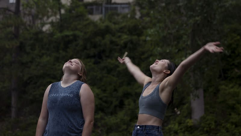 Meredith Covey and Kate Ades enjoy the rain in Salt Lake City on Wednesday, Aug. 2, 2023.
