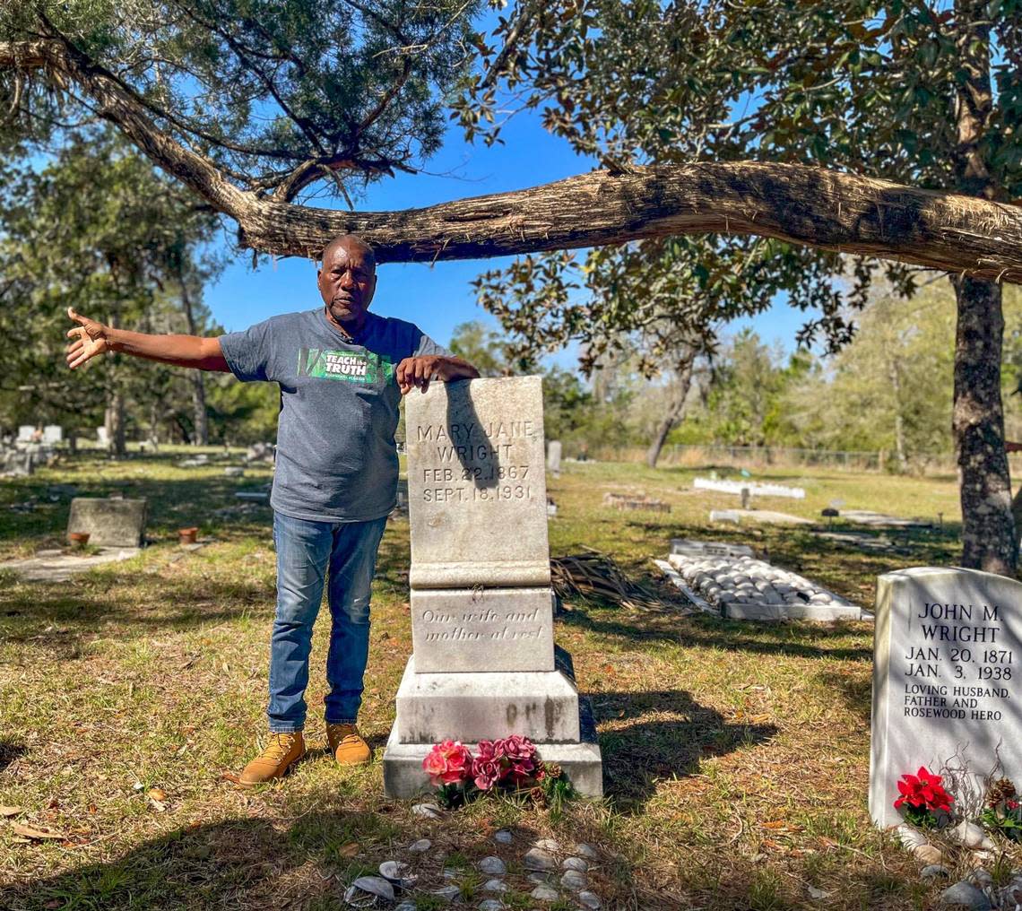 Historian Marvin Dunn leans on the tombstone of Mary Jane Wright at Shiloh Cemetery in Cedar Key, Fla. on Sunday, March 5, 2023. Wright and her husband John hid Black women and children inside the attic of their North Florida home when the bloodshed of the 1923 Rosewood Massacre began.