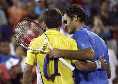 Roger Federer of Switzerland (R) and Tommy Robredo of Spain embrace at the net after Robredo defeated Federer in three sets at the U.S. Open tennis championships in New York September 2, 2013. REUTERS/Eduardo Munoz