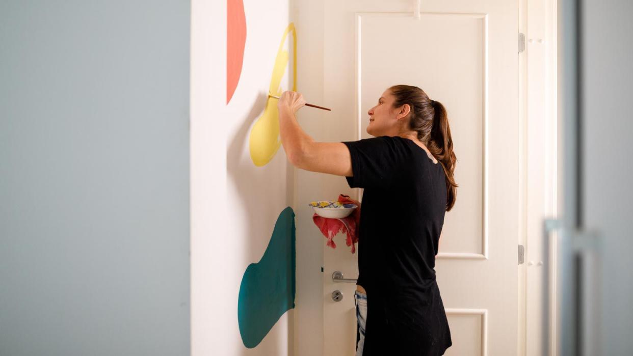 A woman painting abstract colored forms