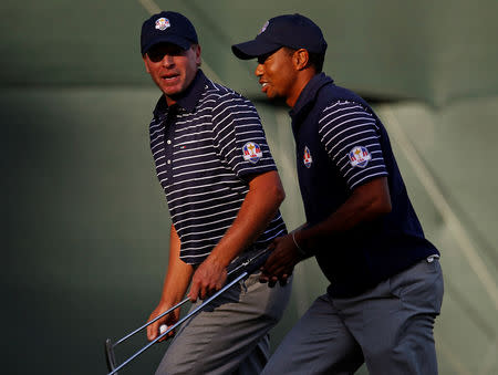 FILE PHOTO: U.S. golfer Tiger Woods (R) leaves the 13th green with teammate Steve Stricker after sinking a birdie putt to win the hole during the afternoon four-ball round at the 39th Ryder Cup golf matches at the Medinah Country Club in Medinah, Illinois, September 29, 2012. REUTERS/Jim Young