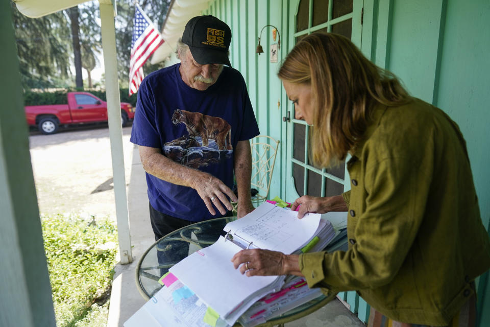 Steve Loe, left, a retired U.S. Forest Service biologist, and Amanda Frye, right, look over binders of evidence on Friday, Sept. 15, 2023, in Redlands, Calif. The two have led efforts to stop BlueTriton, the company that produces the widely-known Arrowhead brand of bottled water, from drawing water from certain points in the San Bernardino National Forest. The State Water Resources Control Board is expected to vote Tuesday on whether to issue a cease-and-desist order against BlueTriton. (AP Photo/Ashley Landis)