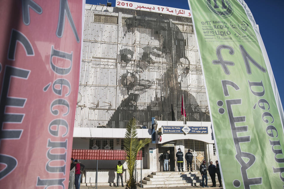 An image of Mohammed Bouazizi is depicted on the facade of the post office building, in Sidi Bouzid, Tunisia, Friday, Dec. 17, 2021. President Kais Saied changed the anniversary date of Tunisia's 2011 revolution – when former autocratic ruler Zine el Abidine Ben Ali fled the country – to Dec. 17 to mark the day in 2010 when fruit seller Mohammed Bouazzi set himself alight, setting off the series of uprisings in Tunisia that led to what is now known as the Arab Spring.in Sidi Bouzid, Tunisia, Friday, Dec. 17, 2021. (AP Photo/Riadh Dridi)