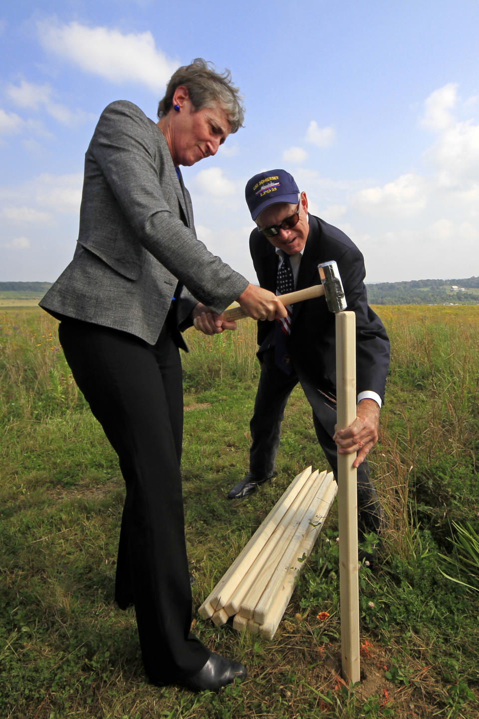 Secretary of the Interior Sally Jewell, left, pounds a stake held by Patrick White, vice president of the Families of Flight 93, pounds it into the ground as part of a ground breaking ceremony for the Flight 93 National Memorial visitor center complex on Tuesday, Sept. 10, 2013, in Shanksville, Pa. (AP Photo/Gene J. Puskar)