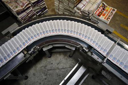 Newspapers roll down on a conveyer belt inside the Dainik Jagran printing press in Noida, on the outskirts of New Delhi February 25, 2014. REUTERS/Anindito Mukherjee