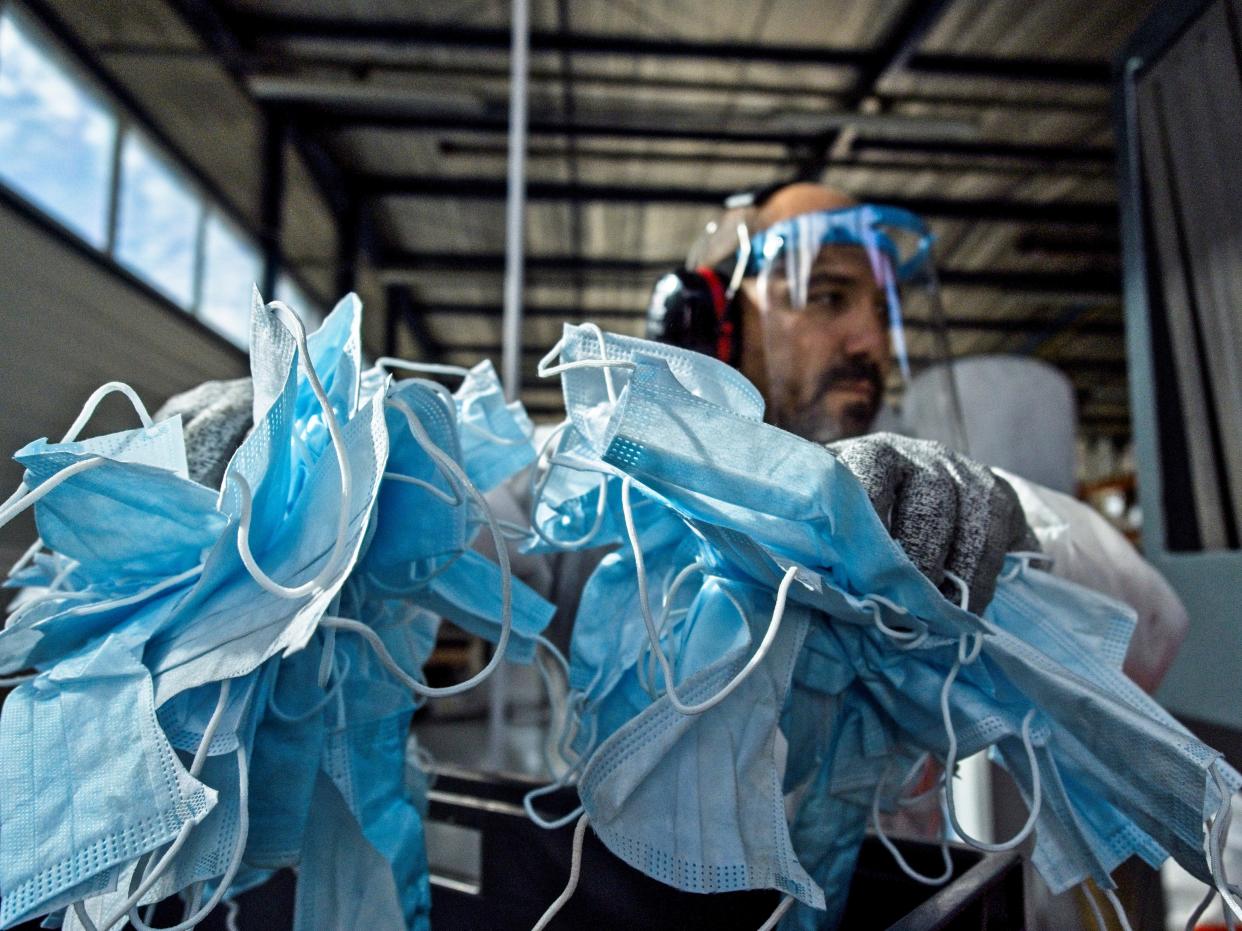 A worker at the start-up Plaxtil, in France, with masks to be recycled into plastic to make visors, door openers, and more. (Photo: GUILLAUME SOUVANT/AFP via Getty Images)