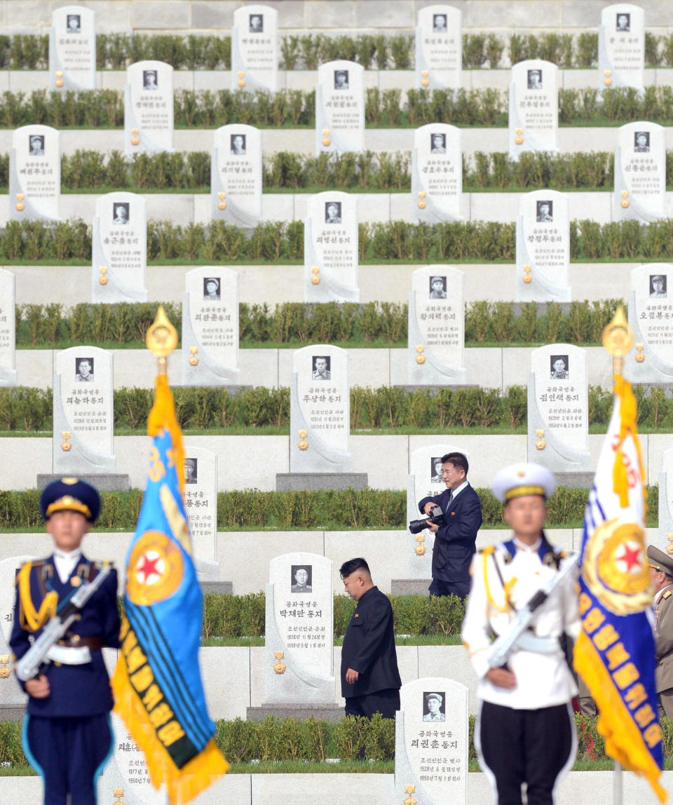 North Korean leader Kim Jong Un, center, walks through a cemetery for Korean War veterans on Thursday, July 25, 2013 in Pyongyang, North Korea marking the 60th anniversary of the signing of the armistice that ended hostilities on the Korean peninsula. (AP Photo/Kyodo News)