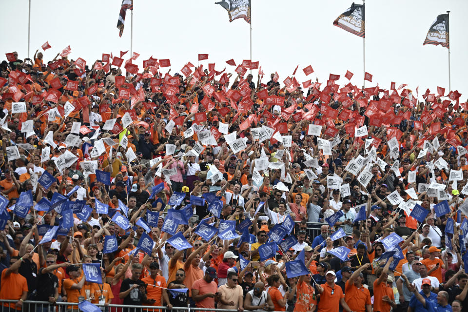 Fans wave flags on the stands during the Formula One Dutch Grand Prix auto race, at the Zandvoort racetrack, in Zandvoort, Netherlands, Sunday, Sept. 4, 2022. (Christian Bruna/Pool via AP)