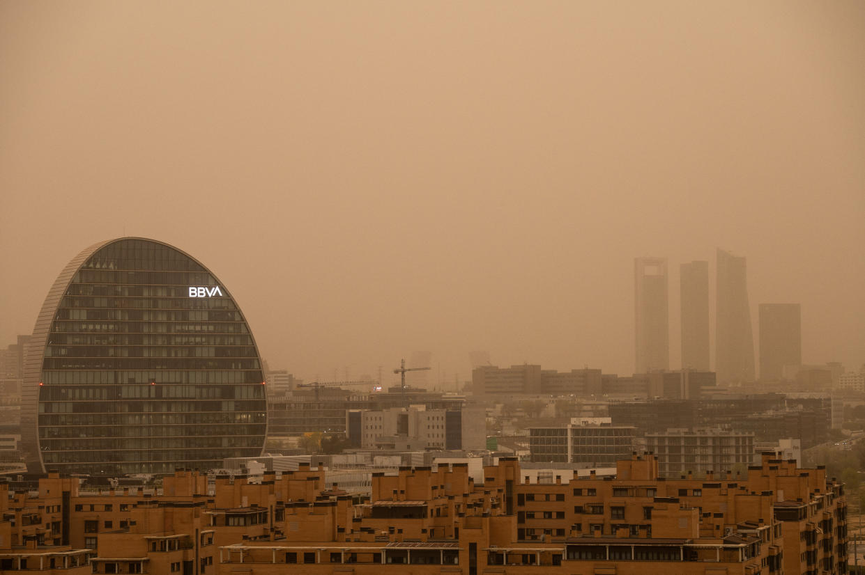 MADRID, SPAIN - 2022/03/15: BBVA bank headquarters and Four Towers Business Area are seen with mist generated by a high amount of dust particles in suspension coming from the Sahara, causing a decrease in air quality, sand in the streets, a reddish sky and rising temperatures. The Community of Madrid has advised to limit outdoor activities due to the bad air quality. (Photo by Marcos del Mazo/LightRocket via Getty Images)