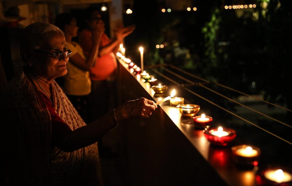 People light candles and flash lights in a residential complex in Mumbai: EPA