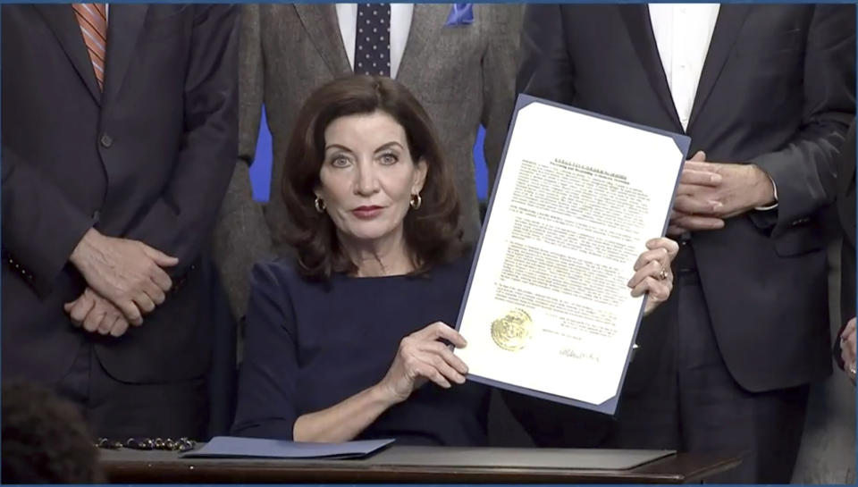 In this image taken from video, New York Gov. Kathy Hochul shows an executive e order she signed during a news conference, Wednesday, May 18, 2022, in New York. New York would require state police to seek court orders to keep guns away from people who might pose a threat to themselves or others under a package of executive orders and gun control bills touted Wednesday by Hochul in the aftermath of a racist attack on a Buffalo supermarket. (Office of the Governor of New York via AP)
