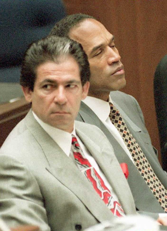 robert kardashian sitting and looking to his right as oj simpson leans forward with his eyes closed