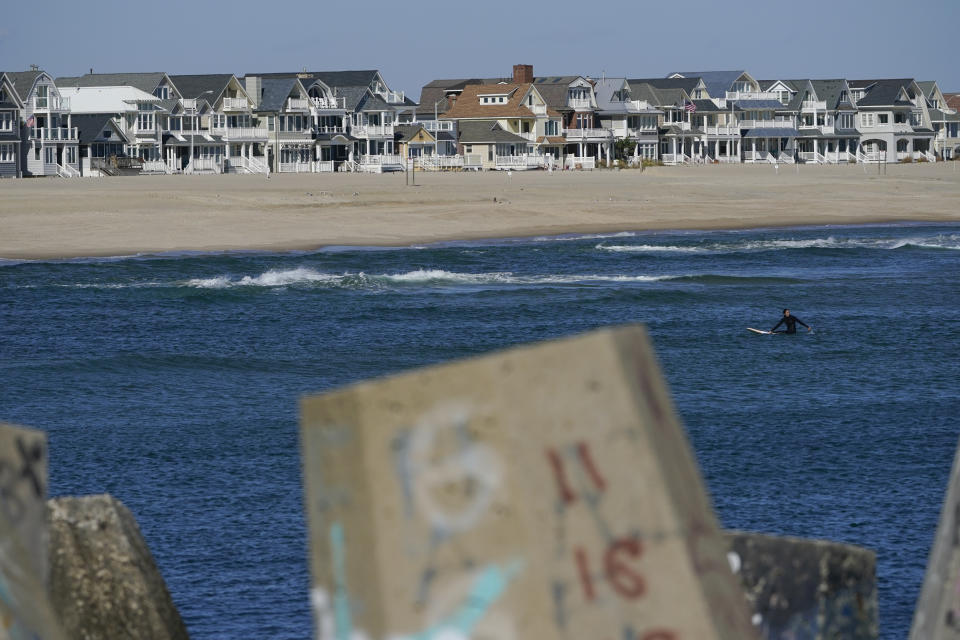 Houses line the beach in Manasquan, N.J., Thursday, Oct. 20, 2022. For houses along this section of the New Jersey shore, back-bay flooding, from water entering the inlet, can be as much of a concern as ocean surges during large storms. (AP Photo/Seth Wenig)