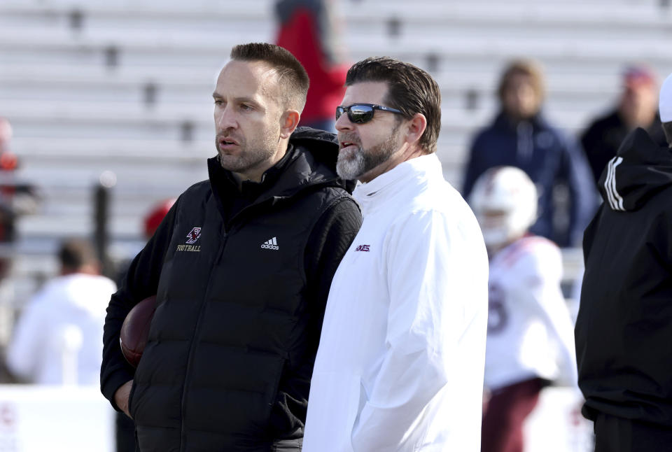 Boston College head coach Jeff Hafley, left, and Virginia Tech head coach Brent Pry speak to each other before an NCAA college football game Saturday, Nov. 11, 2023 in Boston. (AP Photo/Mark Stockwell)