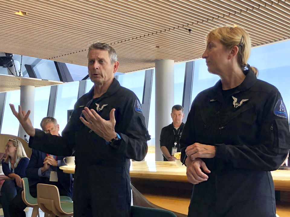 Virgin Galactic pilots Mark "Forger" Stucky and Kelly Latimer discuss their morning test flight at Spaceport America near Upham, New Mexico, on Thursday, Aug. 15, 2019. Spaceport America is no longer just a shiny shell of hope that space tourism would one day launch from this remote spot in the New Mexico desert. (AP Photo/Susan Montoya Bryan)