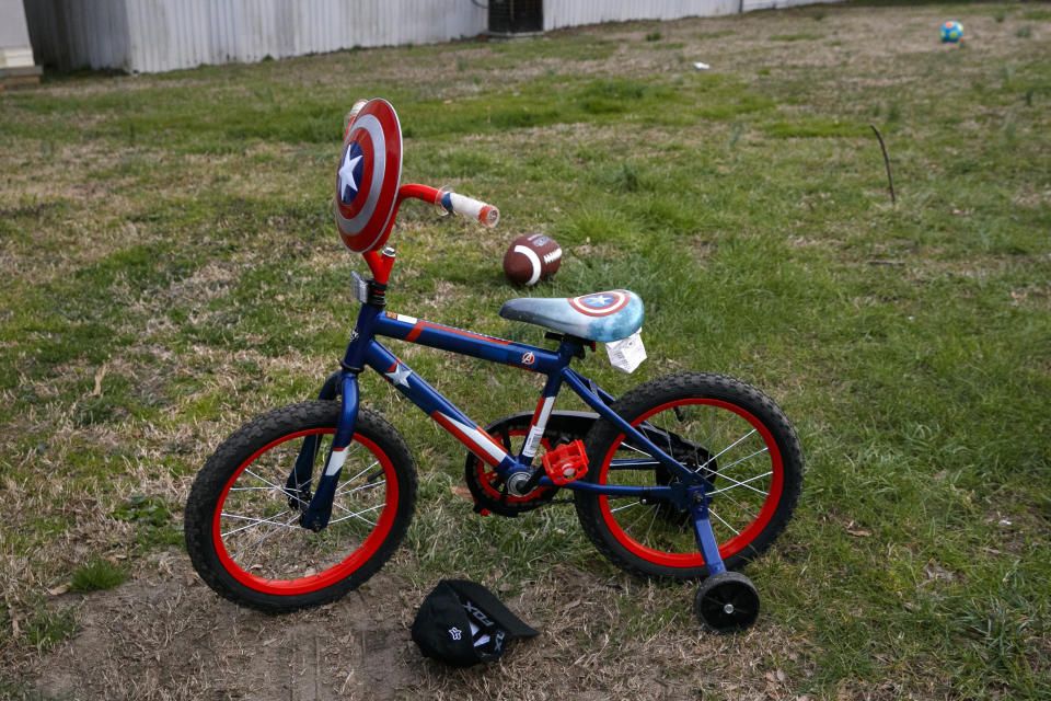 Una bicicleta decorada de Capitán América, en un jardín en un parque de casas rodantes de mayoría latina en Burlington, Carolina del Norte, el miércoles 11 de marzo de 2020. (AP Foto/Jacquelyn Martin)