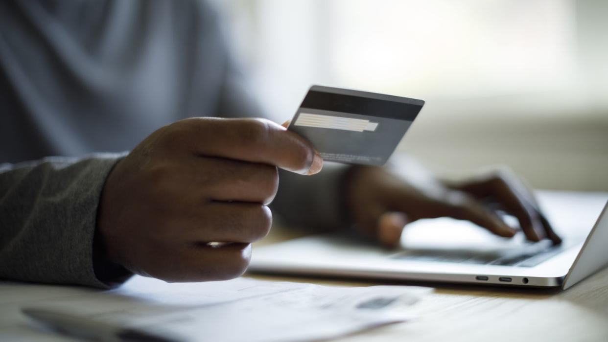 man using credit card and laptop for online shopping