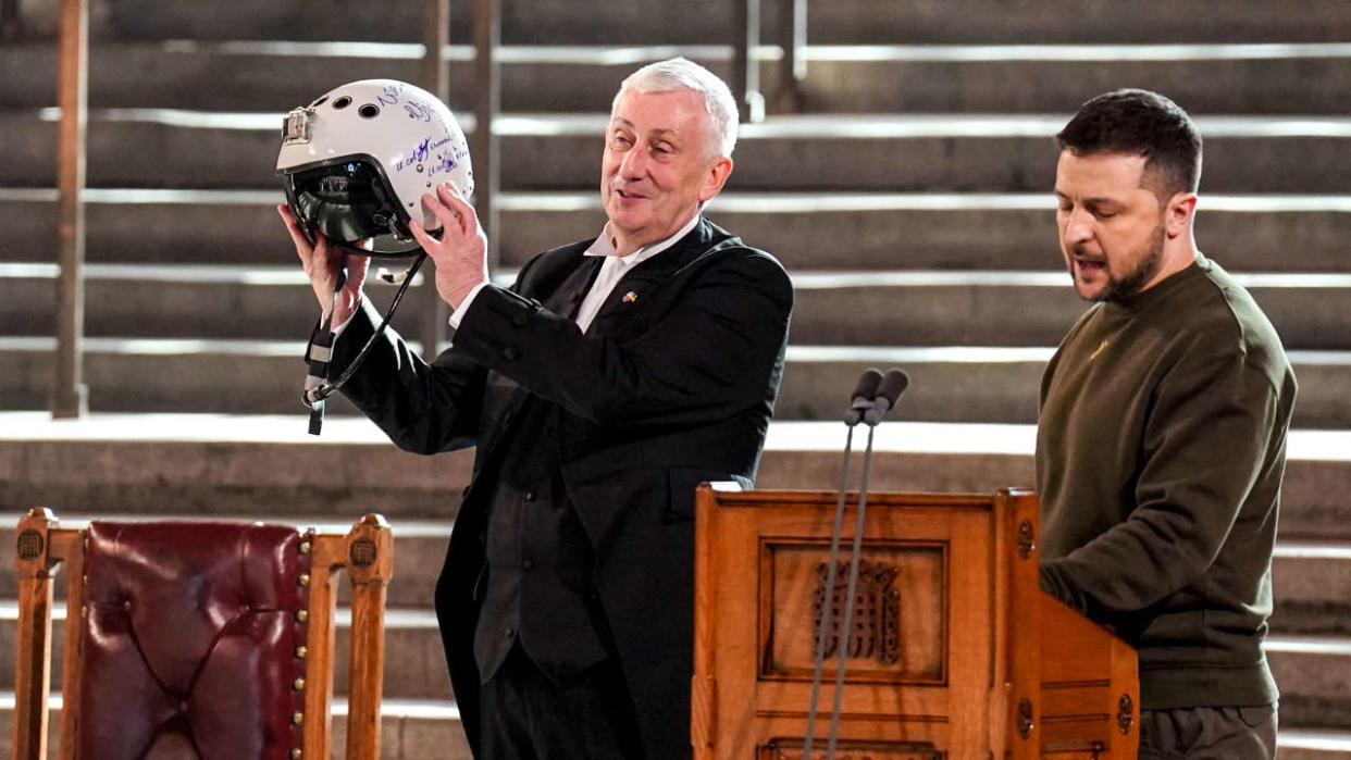 TOPSHOT - Speaker of the House of Commons, Sir Lindsay Hoyle (L), holds the helmet of one of the most successful Ukrainian pilots, inscribed with the words 