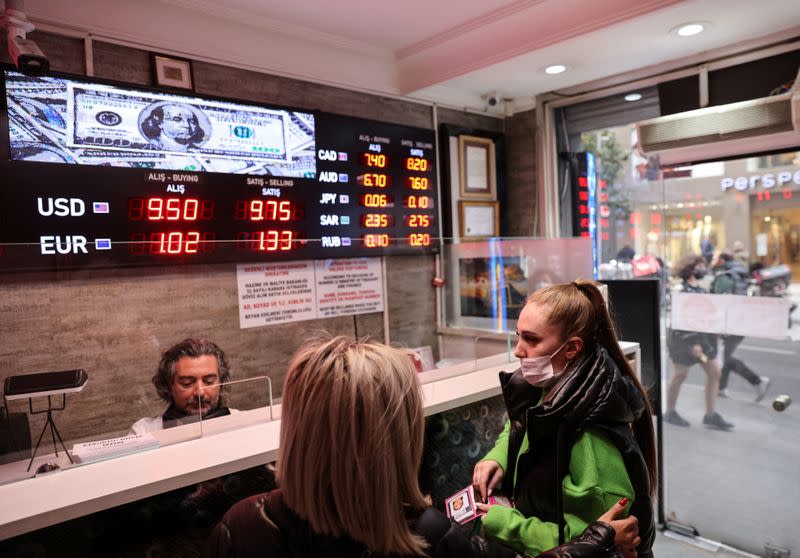 People buy and sell money at a currency exchange office in Istanbul