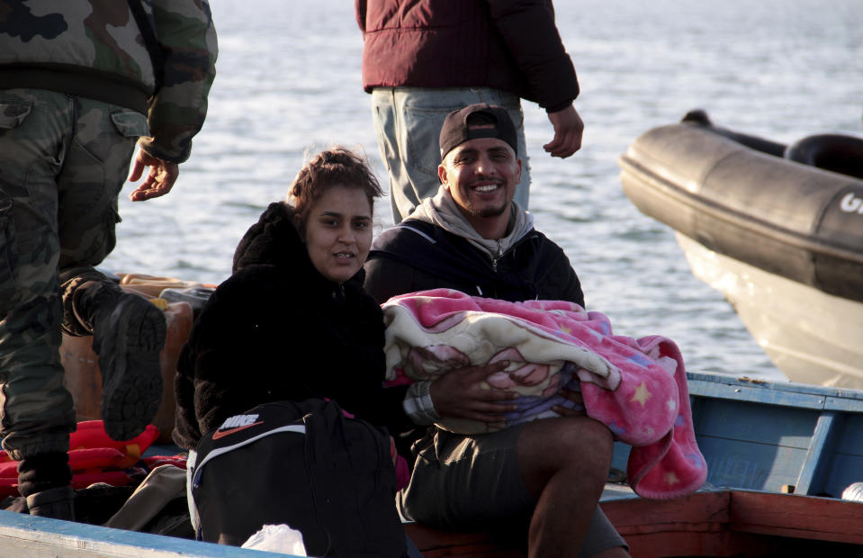 A couple and their child board a boat after getting stopped by Tunisian Maritime National Guard at sea during an attempt to get to Italy, near the coast of Sfax, Tunisia, Tuesday, April 18, 2023. The Associated Press, on a recent overnight expedition with the National Guard, witnessed migrants pleading to continue their journeys to Italy in unseaworthy vessels, some taking on water. Over 14 hours, 372 people were plucked from their fragile boats. (AP Photo)