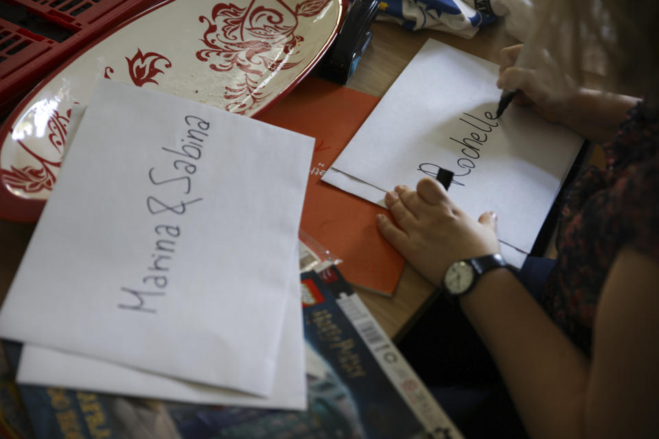 Marta Saracyn, the head of the Jewish Community Center of Warsaw, writes down names of the children at the Lauder Morasha Jewish school in Warsaw, Poland, Thursday, July 28, 2022. A special summer camp run by Jewish organizations has brought Jewish volunteers from the former Soviet Union to Warsaw to help Ukrainian children. The camp, which ran for most of July and ended Friday, was organized to bring some joy to traumatized children, help prepare them for the school year ahead in Polish schools and give their mothers some time to themselves. (AP Photo/Michal Dyjuk)