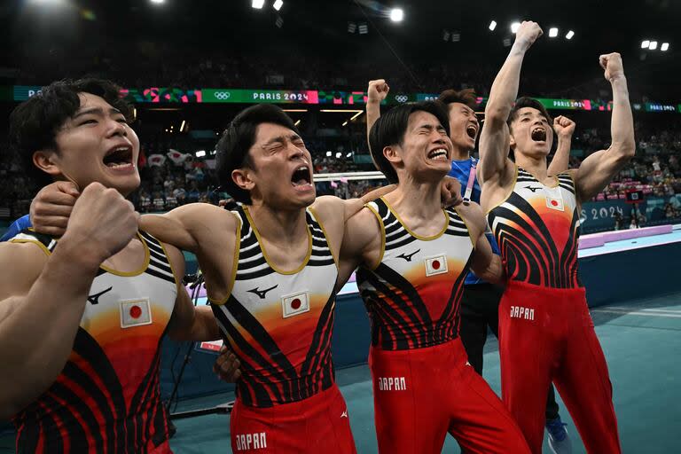 El equipo de Japón celebra después de ganar la medalla de oro durante la final por equipos masculinos de gimnasia artística