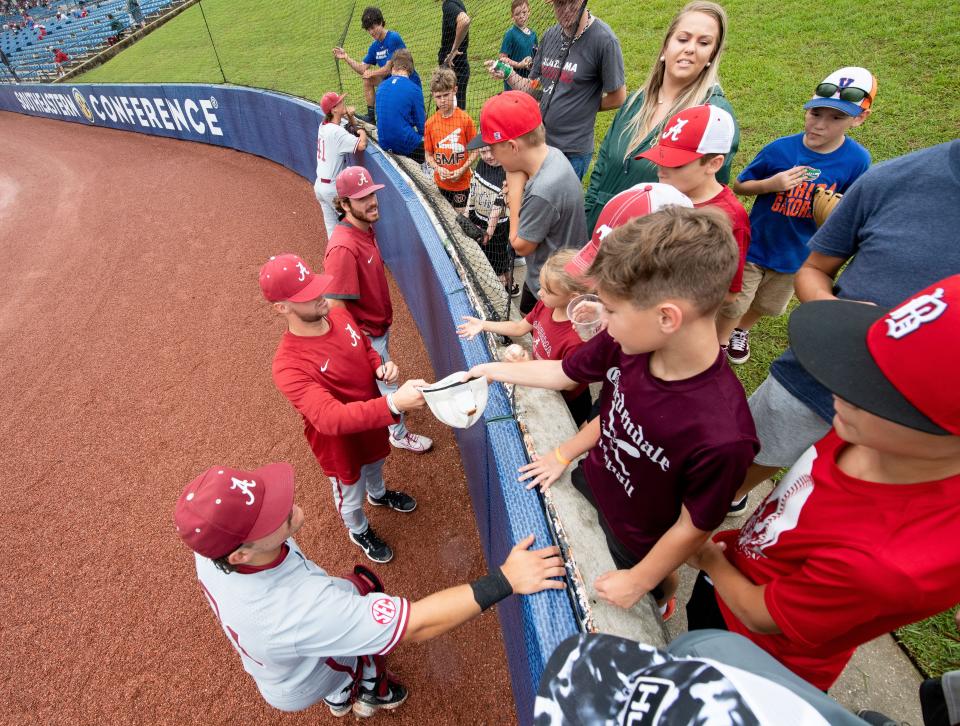 May 24, 2022; Hoover, AL, USA; Alabama players sign autographs for young fans during a rain delay in the game against Georgia in game one of the SEC Tournament at Hoover Met. Mandatory Credit: Gary Cosby Jr.-The Tuscaloosa News