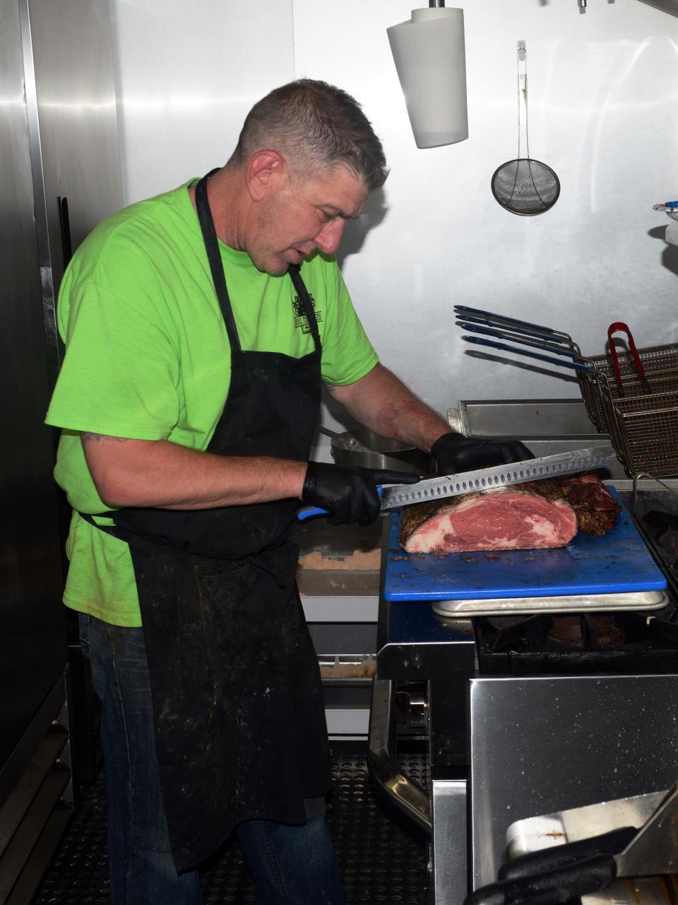 Chef Brian Waller, of the Horns, Fins & Feathers food truck, cuts prime rib during a stop on May 28 at Stone Crest Vineyard and Winery. The Zanesville-based business, registered in all 88 Ohio counties, specializes in fresh meat and seafood not often seen in food trucks. 