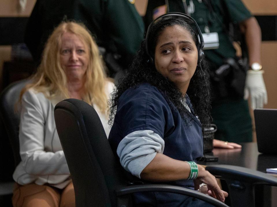 Interpreter Susan Dix-Barboza, left, watches as Rafaelle Sousa looks back at her family during a hearing on Jan. 13, 2020, in West Palm Beach, Fla.