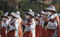 Buddhist monks pray upon their arrival at Bongeun temple in Seoul, South Korea, Tuesday, Oct. 27, 2020. About 100 monks and believers marched the 500-kilometer (310-mile) pilgrimage to wish for the country to overcome the coronavirus. (AP Photo/Lee Jin-man)