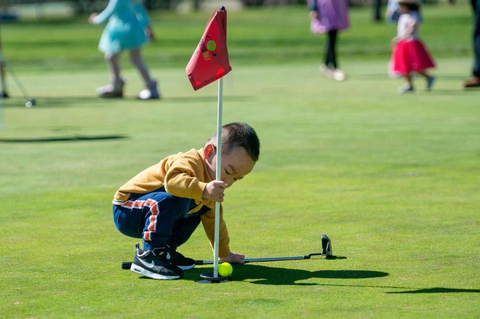 Akon Xie, 1, plays on the putting green before the Haggin Oaks Easter Egg Hunt on Sunday, April 9, 2023, in Sacramento.