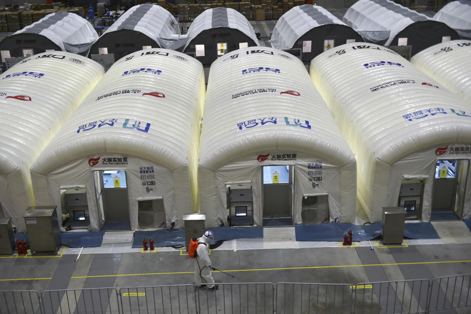 A worker disinfects the flooring outside the inflated cabins at the pop-up Huo-Yan Laboratory set up in an expo center to test samples for covid-19 virus in Nanjing in east China's Jiangsu province Wednesday, July 28, 2021. China's worst coronavirus outbreak since the start of the pandemic a year and a half ago escalated Wednesday, Aug. 4, 2021, with dozens more cases around the country, the sealing-off of one city and the punishment of its local leaders. (Chinatopix Via AP)