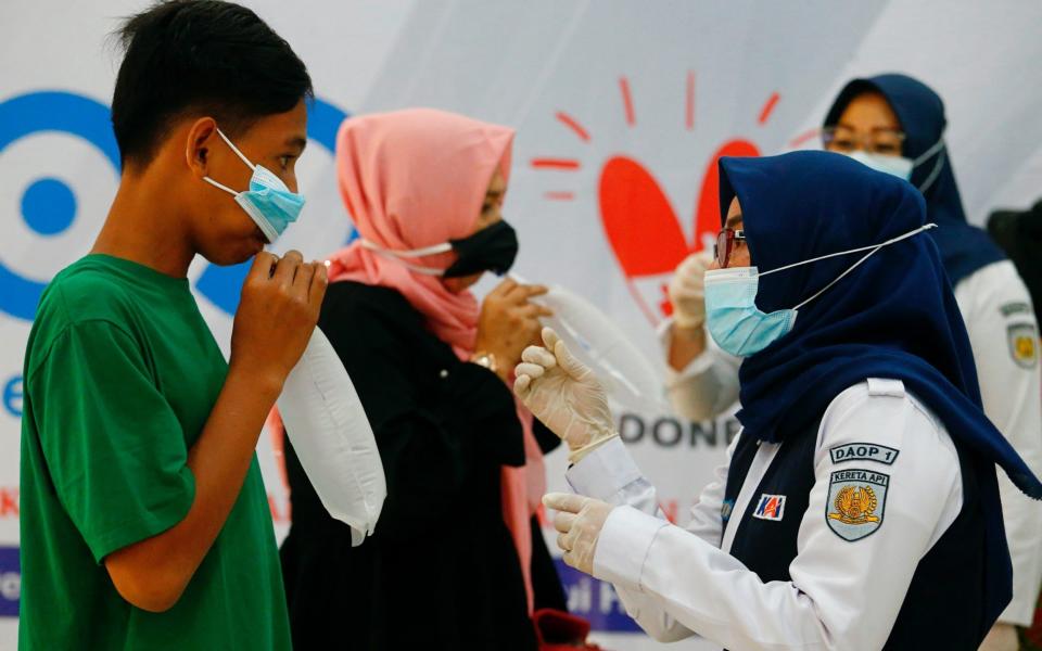 Commuters take their air-samples to be tested for Covid-19 in Jakarta - Ajeng Dinar Ulfiana/Reuters