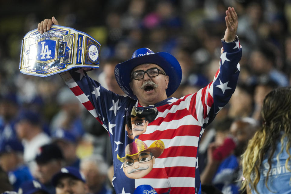 A Los Angeles Dodgers fan cheers during the eighth inning of a baseball game against the Colorado Rockies in Los Angeles, Friday, May 31, 2024. (AP Photo/Ashley Landis)